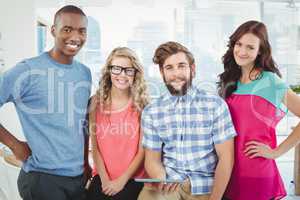 Portrait of smiling business people with man holding digital tab