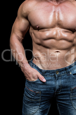 Midsection of shirtless man with hands in pocket