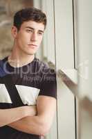 Close-up of thoughtful male student leaning on window
