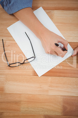 Hipster writing in paper at desk