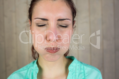 Close-up of woman with eyes closed while making face