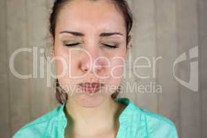 Close-up of woman with eyes closed while making face