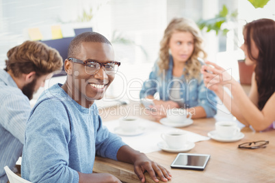 Portrait of smiling man wearing eyeglasses while sitting at desk