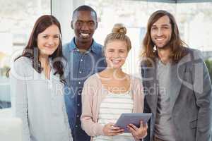 Portrait of smiling business team with woman holding digital tab