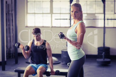 Sporty couple exercising with dumbbells