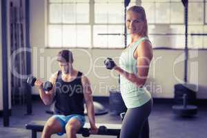 Sporty couple exercising with dumbbells