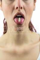 Woman with pill in mouth