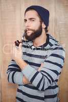 Portrait of serious hipster smoking pipe