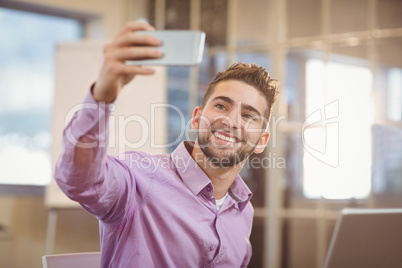 Businessman taking selfie in creative office