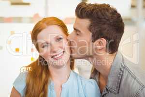 Portrait of smiling businesswoman being kissed