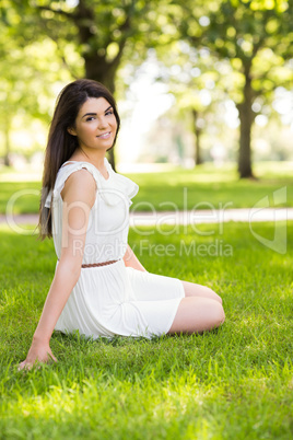 Portrait of happy woman sitting on grassland