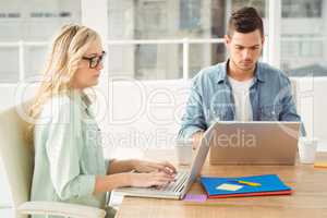 Serious people working on laptop while sitting at desk
