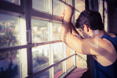 Serious man looking outside from window