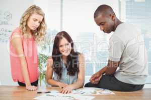 Portrait of smiling woman with business people working at desk