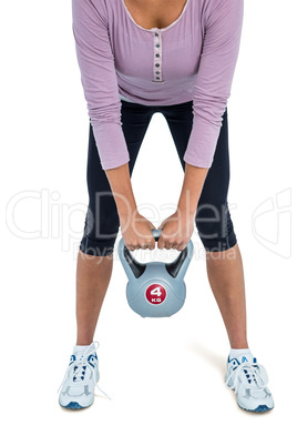 Low section of woman exercising with kettlebell