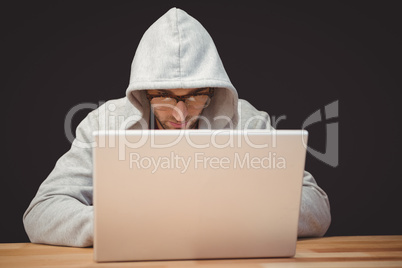 Creative businessman with hooded shirt working on laptop