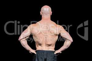 Rear view of confident bald man with hands on hip
