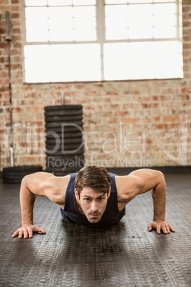 Focused man doing wide arm push ups