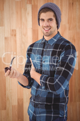 Portrait of happy man holding smoking pipe