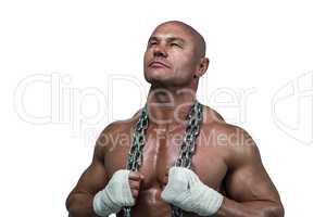 Confident bodybuilder holding chain while looking up