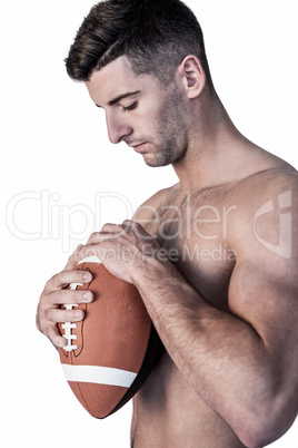Rugby player holding the ball while looking down