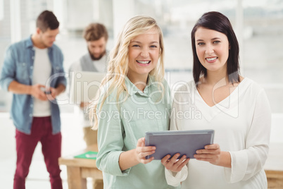 Portrait of smiling women holding digital tablet
