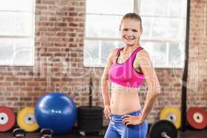 Smiling muscular woman with hands on hips