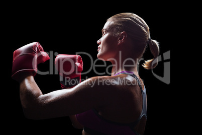 Side view of female boxer with fighting stance