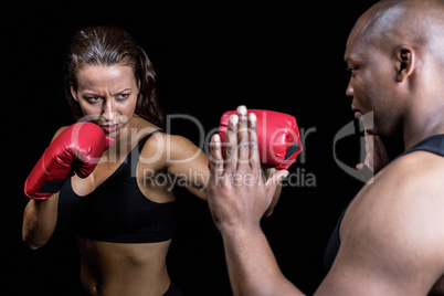 Female boxer practicing with trainer