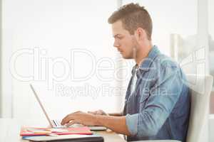 Side view of young man working on laptop