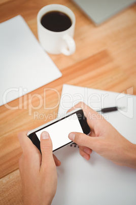 Man using smartphone at desk in office