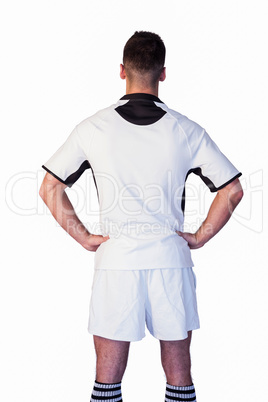 Rear view of rugby player with arms on waist