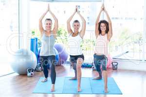 Happy women with joined hands in fitness studio