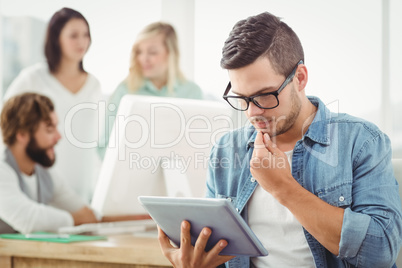 Man wearing eyeglasses using digital tablet