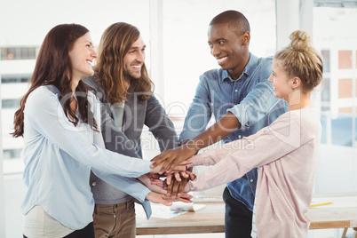 Smiling business team putting their hands together