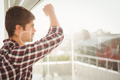 Side view of hipster looking through window