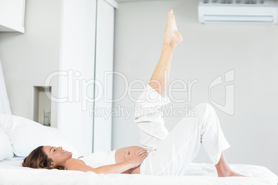 Happy woman with leg up on bed