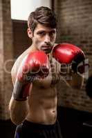 Portrait of serious man wearing boxing gloves