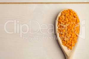 Wooden spoon of red lentils