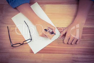 Man writing in paper at desk