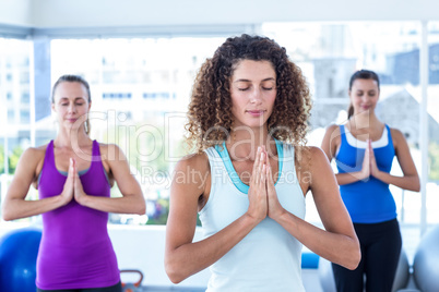 Focused women in fitness studio with hands joined