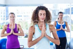 Focused women in fitness studio with hands joined