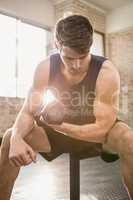 Man lifting dumbbell while sitting