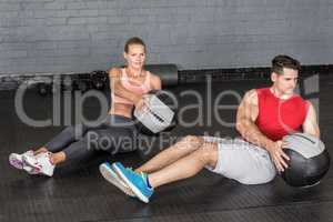 Muscular couple doing ball exercise