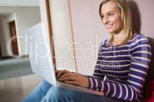 Female student smiling while using laptop