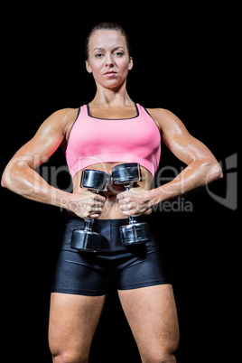 Portrait of healthy woman exercising with dumbbells