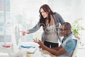 Business people gesturing while looking at computer