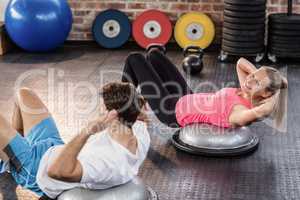 Fit couple doing abdominal crunches