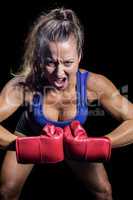 Portrait of aggressive female fighter flexing muscles