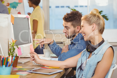 Happy business people looking at computer